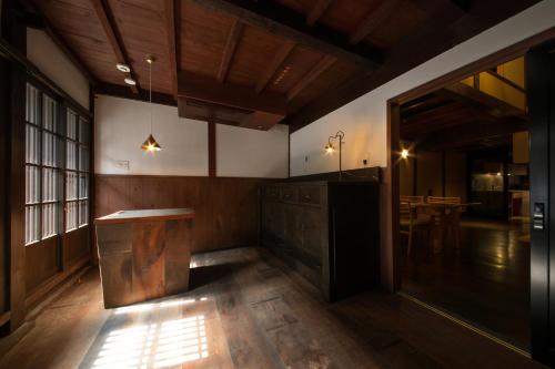 a room with a wooden desk and a table at 民家ホテル「金ノ三寸」(かねのさんずん） in Takaoka