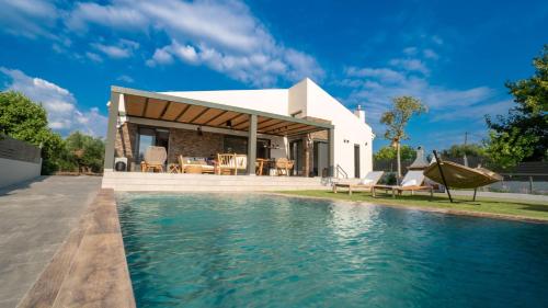 une maison avec une piscine en face d'une maison dans l'établissement Luxury Country House, à Mavrommátion