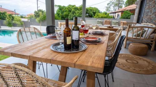 a wooden table with wine bottles and glasses on it at Luxury Country House in Mavrommátion