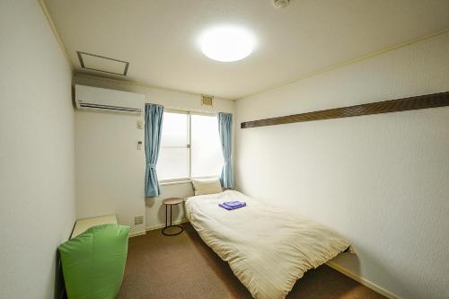 芝山町にある成田スカイパークイン芝山のベッドと窓が備わる小さな客室です。