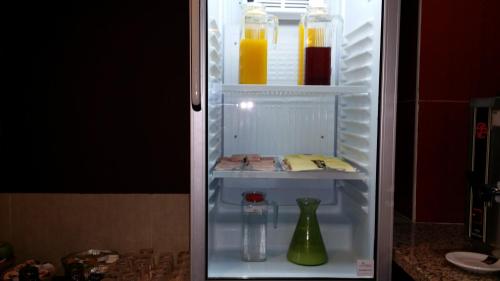 an open refrigerator with drinks and a vase in it at Residencial Pinto in Guarda