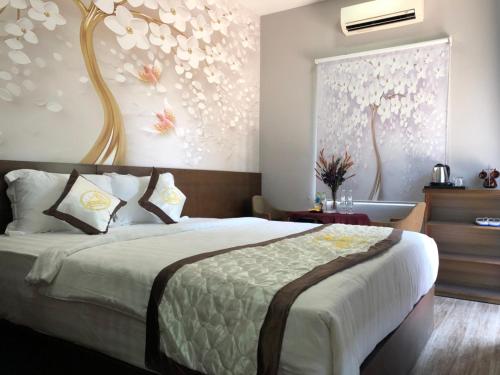 a bedroom with a large bed with flowers on the wall at Sang Như Ngọc Resort in Chau Doc