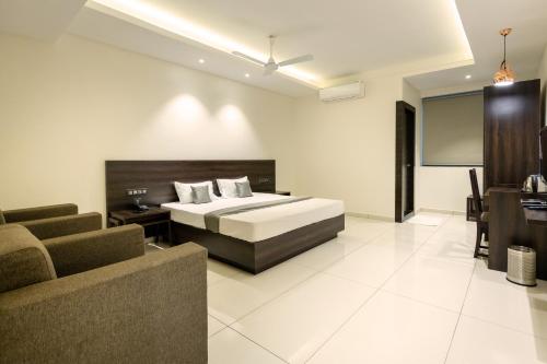 a hotel room with a bed and a couch at Hotel Paramount Suites & Service Apartments in Mangalore