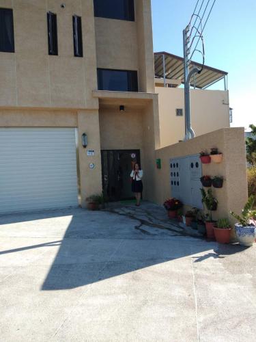 a woman standing at the door of a house at 太魯閣-全欣民宿 in Xincheng