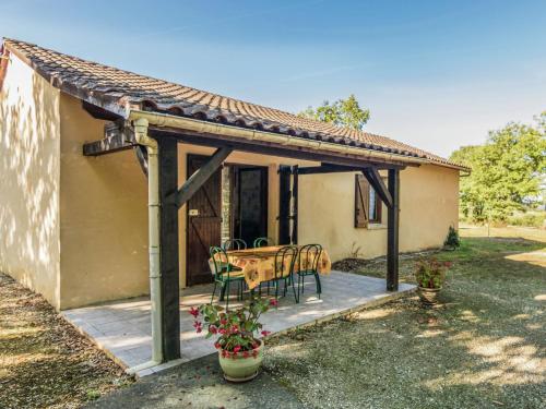 a patio with a table and chairs in front of a house at Holiday home with swimming pool in Salignac