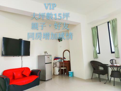 a living room with a red couch and a tv at 太魯閣-全欣民宿 in Xincheng