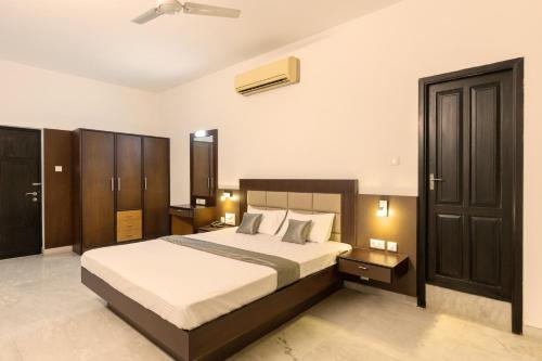 a bedroom with a large bed and aokedokedokedokedoked at Hotel Paramount Suites & Service Apartments in Mangalore