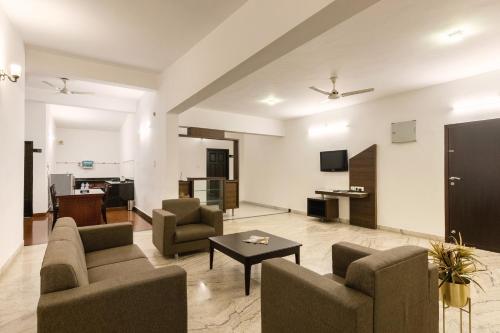 a living room with two couches and a table at Hotel Paramount Suites & Service Apartments in Mangalore