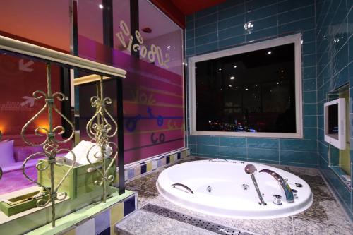 a bathroom with a tub and a shower and a sink at Vov Hotel in Busan