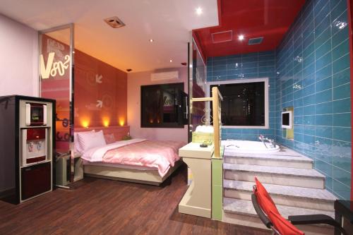 a bedroom with a bed and a sink and a tub at Vov Hotel in Busan