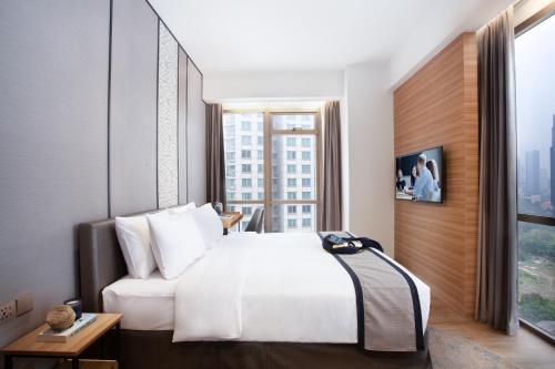 a bedroom with a white bed and a large window at Somerset Sudirman Jakarta in Jakarta