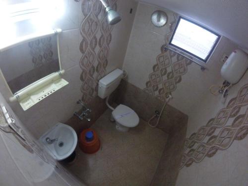 a small bathroom with a toilet and a sink at Just Guest House, Chennai Airport in Chennai