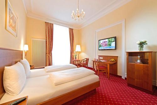 una camera d'albergo con letto e tavolo di Hotel Schweizer Hof - Superior a Baden-Baden