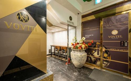 a lobby with a vase with flowers in it at Vov Hotel in Busan