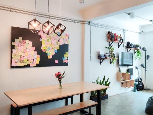 a dining room with a table and a map on the wall at HOLY SHEET Hostel in Bangkok