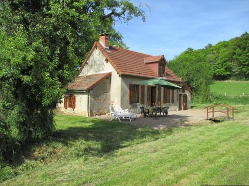 a small house with a picnic table in front of it at Pretty holiday home with garden near forest in Isenay