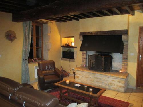 sala de estar con sofá y chimenea en Pretty holiday home with garden near forest, en Isenay