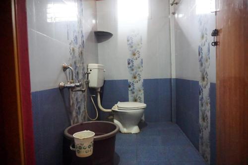 a bathroom with a toilet and a bucket in it at Vamoose Balgal Homestay in Kalasa