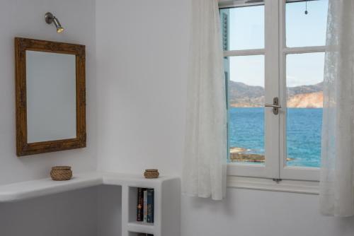 a white room with a window with a view of the ocean at Venia's Guesthouse in Pollonia