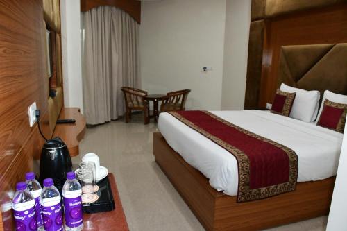 a hotel room with a bed and a table with drinks at HOTEL ANAND INTERNATIONAL in Bodh Gaya