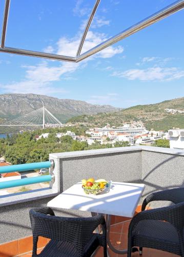 a table with a bowl of fruit on a balcony at Villa Antea Apartments with Free Parking in Dubrovnik