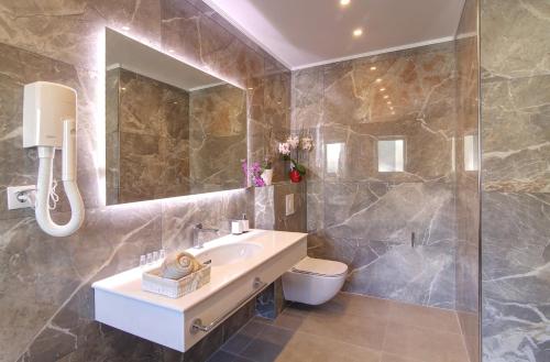 a bathroom with a sink and a toilet and a mirror at Villa Antea Apartments with Free Parking in Dubrovnik