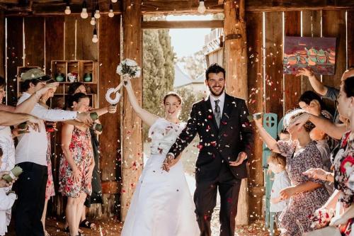 a bride and groom walking down the aisle with confetti at Dingup House in Manjimup