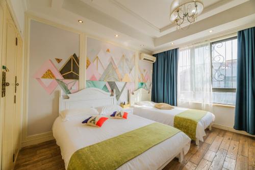 上海市にあるBoyi Apartment - Shanghai National Convention and Exhibition Center Branchのベッドが2つと窓があるホテルの部屋