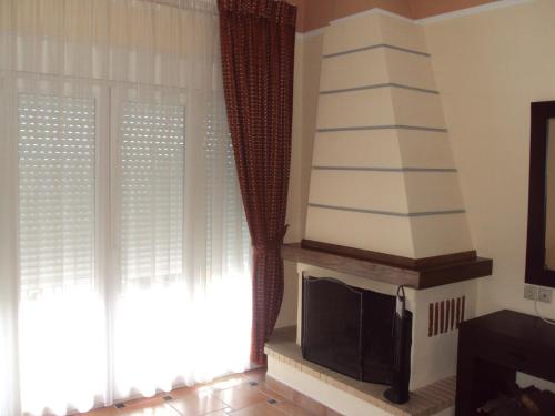 a living room with a tv and two windows at Agrabeli Apartments in Limne