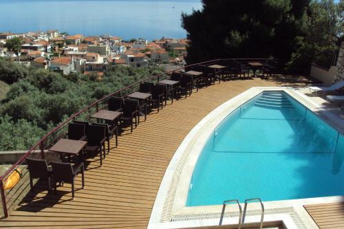 a deck with chairs and a swimming pool on a building at Agrabeli Apartments in Limne