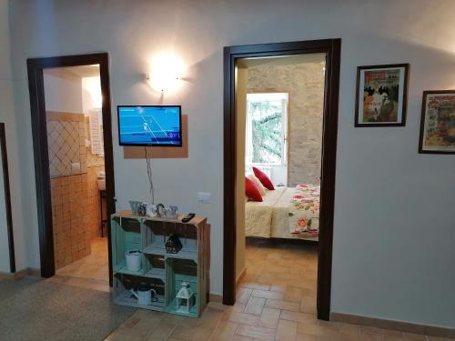 sypialnia z łóżkiem i telewizorem na ścianie w obiekcie La Maisonette del Borgo w mieście Ronciglione