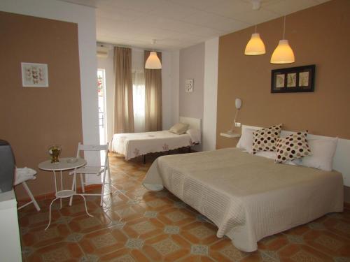 a bedroom with two beds and a small table and a table at El Manantial in Málaga