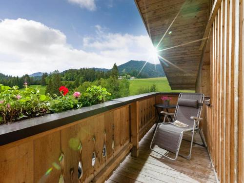 a balcony with a chair and a table and flowers at Ferienwohnung Gasteiger in Steinberg am Rofan
