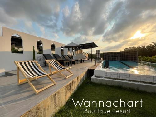 una terraza con tumbonas y una piscina en Wannachart Boutique Resort, en Tha Sala