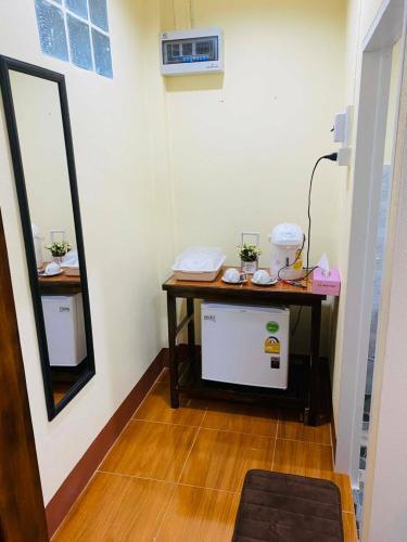 a small room with a table and a mirror at เฮือนป้อหลวง in Ban Fang