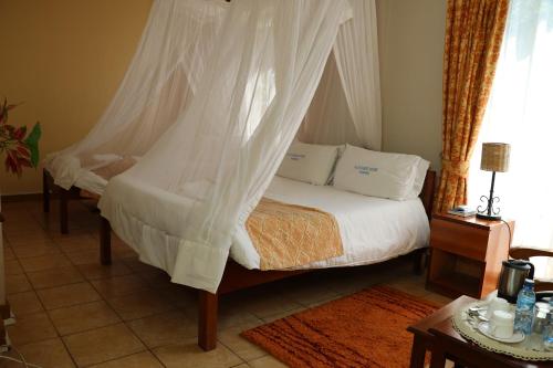 a bedroom with a bed with a mosquito net at ACK Guest House Nairobi in Nairobi