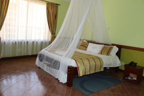 a bedroom with a bed with a mosquito net at ACK Guest House Nairobi in Nairobi