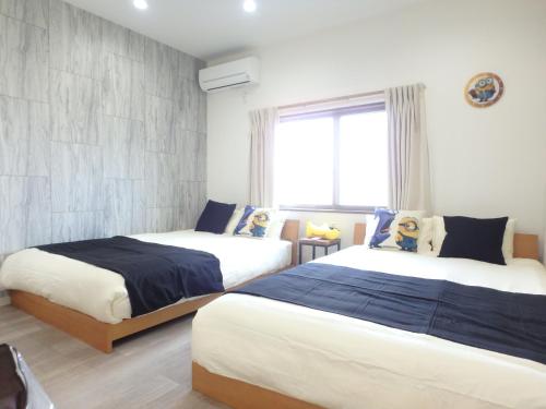 a bedroom with two beds and a window at Sakurajima Building in Osaka