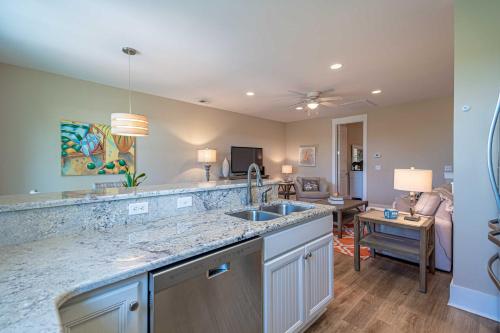 a kitchen with a sink and a living room at Resort Amenities Chic North Myrtle Beach Condo! in Myrtle Beach