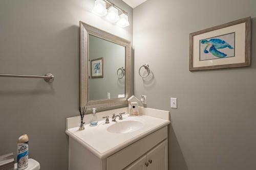 a bathroom with a sink and a mirror at Chic North Myrtle Beach Villa Resort Amenities! in Myrtle Beach
