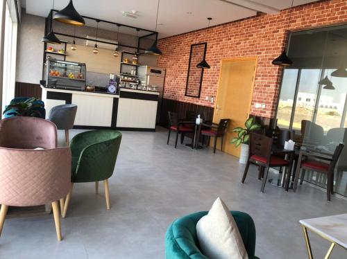 a restaurant with chairs and tables and a brick wall at Sama Muscat Hotel in Al Khawḑ