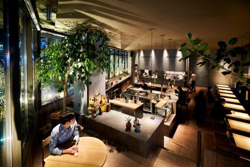 a man sitting at a table in a restaurant at THE REIGN HOTEL KYOTO in Kyoto