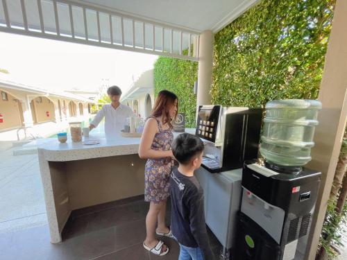 a woman and a young boy standing at a counter at BARA BARA' Budget SATUN 'SHA Plus' in Satun