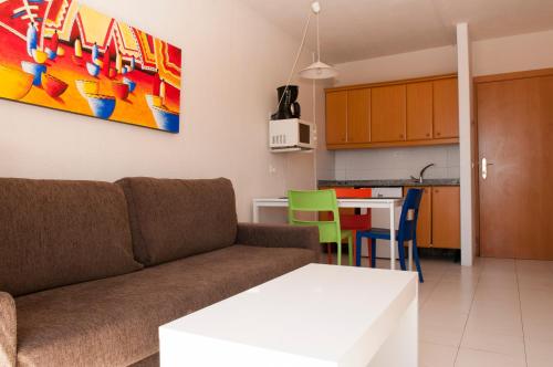 ein Wohnzimmer mit einem Sofa und einer Küche in der Unterkunft Apartamentos Babalu in Puerto Rico de Gran Canaria