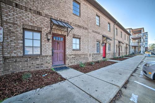 a brick building with a red door on a street at Modern Retreat about half Mi to Bryant-Denny Stadium in Tuscaloosa
