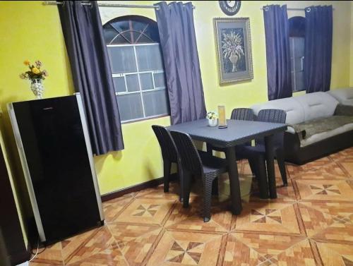 a living room with a table and chairs and a couch at Carribean Transient House in Lucap