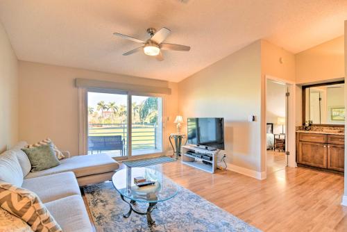 a living room with a couch and a tv at St Pete Condo with Private Lanai and Community Pool! in St Petersburg