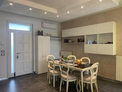 a dining room with a table and chairs and a kitchen at Casa Dai Angioi in Sirmione