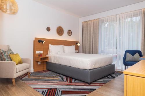 une chambre d'hôtel avec un lit et une chaise dans l'établissement Holiday Inn - Lusaka, an IHG Hotel, à Lusaka