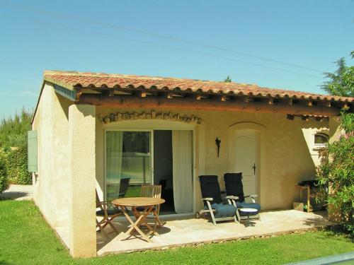 カルパントラにあるCozy cottage in Carpentras with fenced poolの家の前のパティオ(テーブル、椅子付)